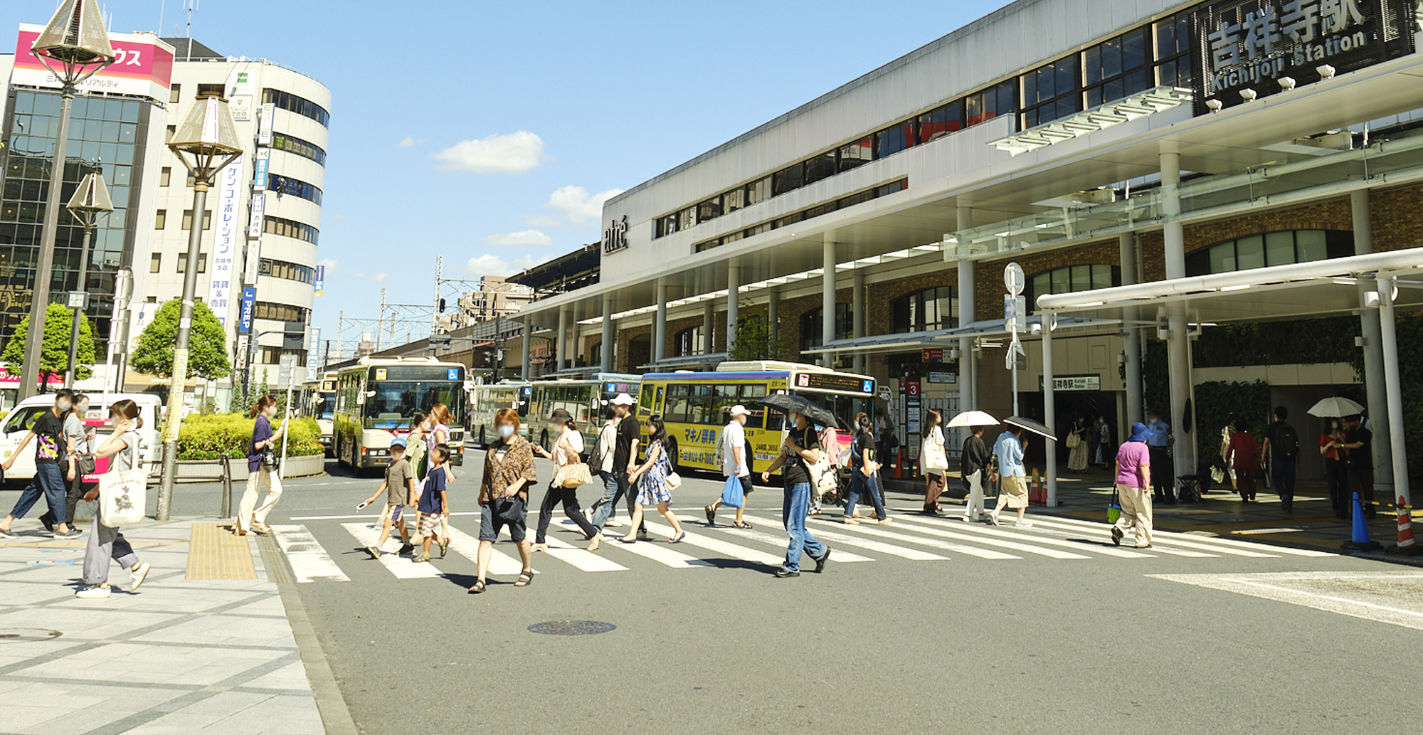 写真：暑そうな日の吉祥寺駅前横断歩道を行き交う人たちの様子