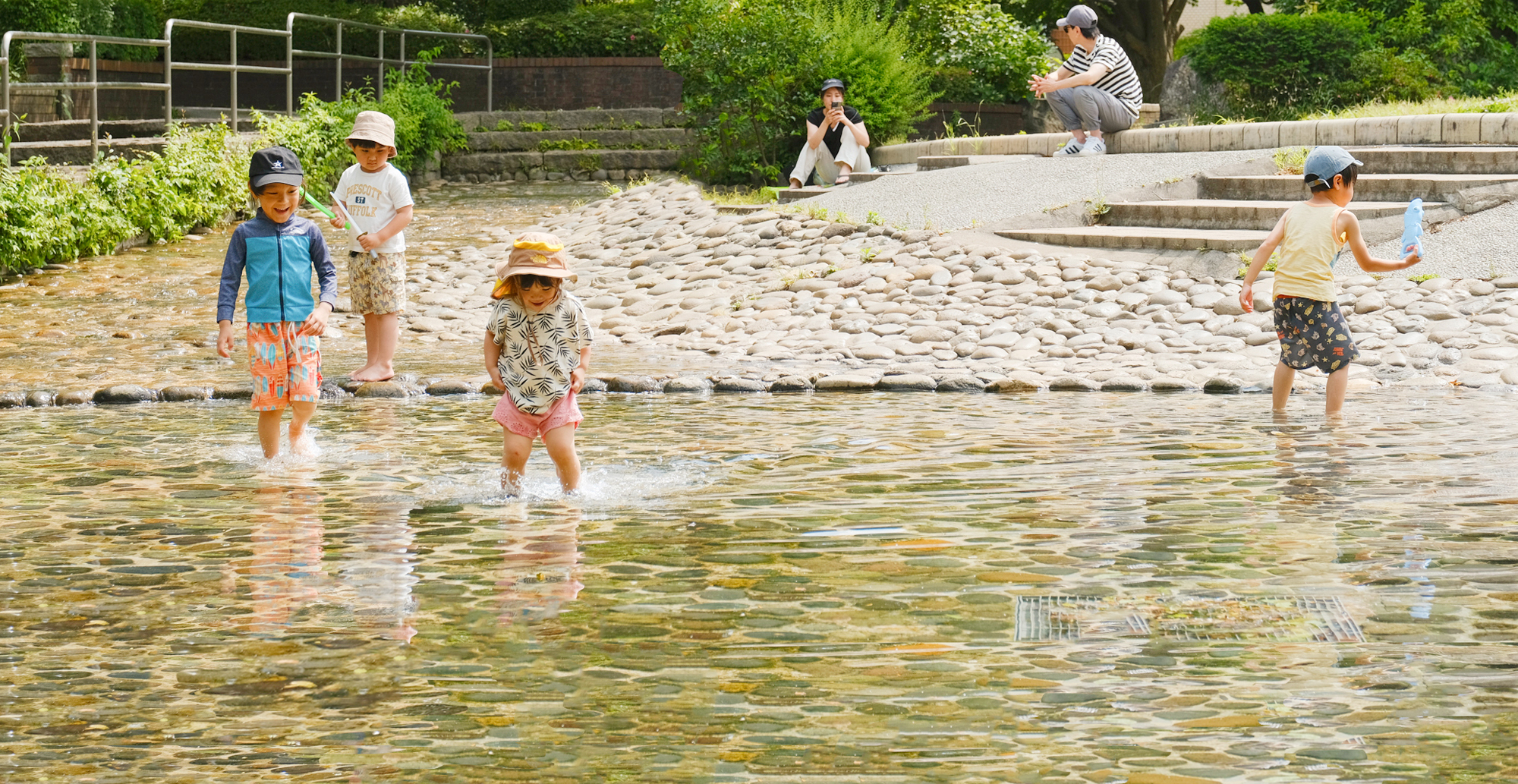 写真：関前公園じゃぶじゃぶ池で遊ぶ子どもの様子