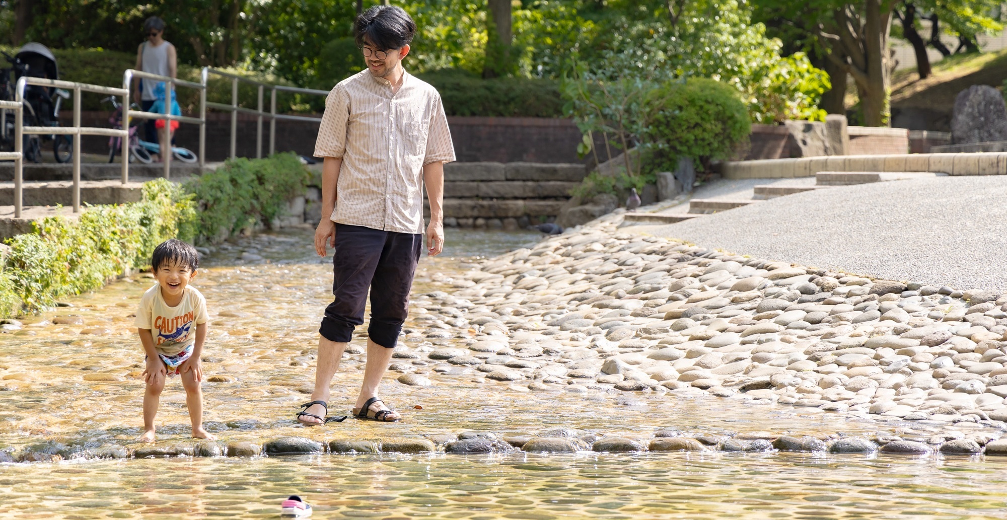 写真：関前公園のじゃぶじゃぶ池で遊ぶ親子