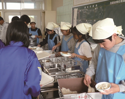 中学生が給食を準備する様子の写真