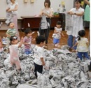 大量の新聞紙で遊ぶ様子